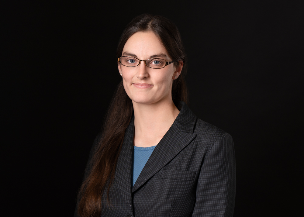 photo of akilah sanders-reed, a white woman with dark hair against a dark background