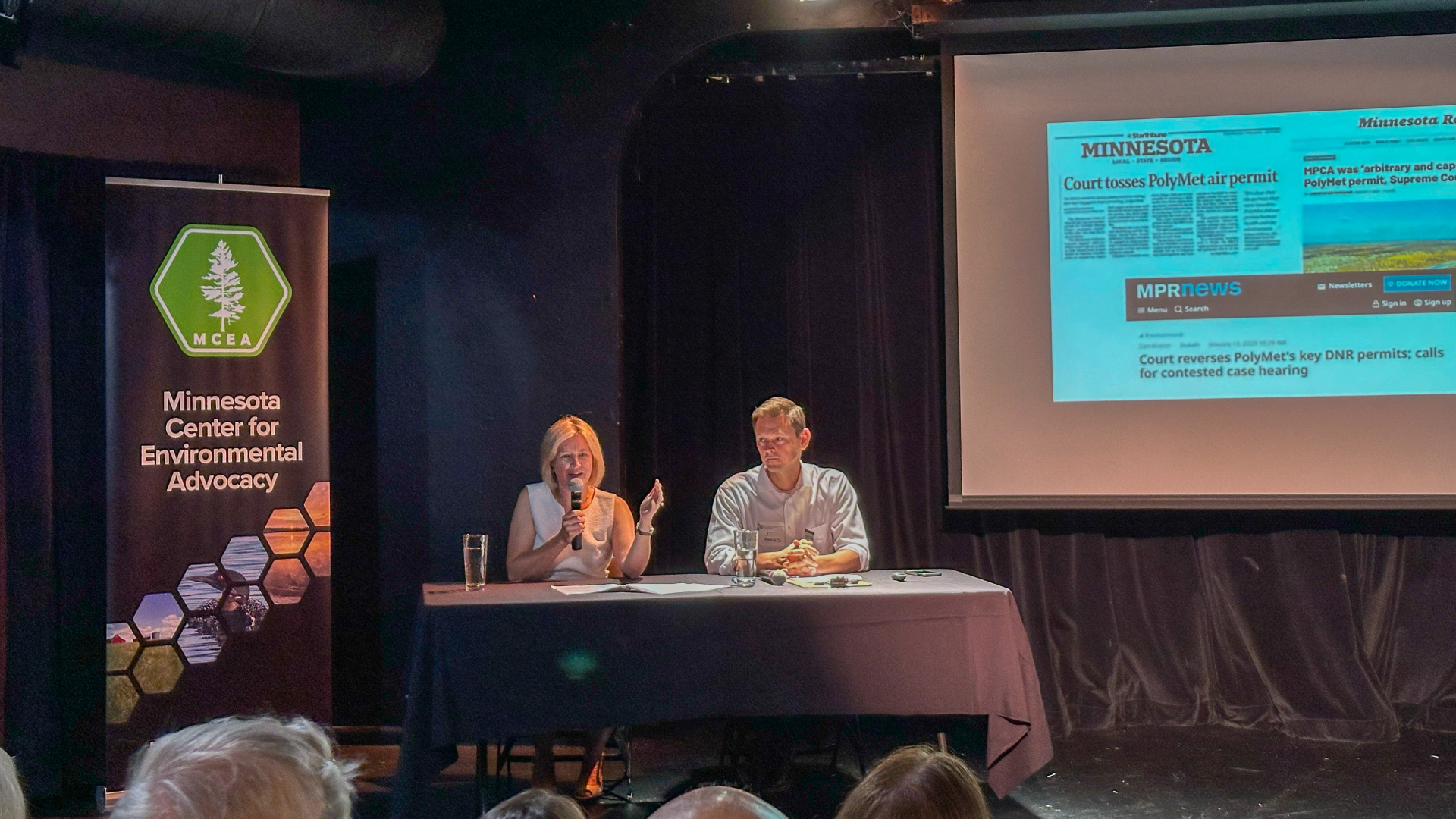 a white man and woman give a presentation on a stage