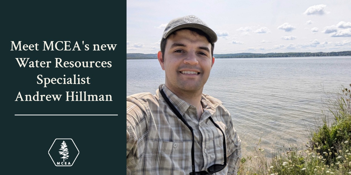 a photo of andrew hillman, a white man in a baseball cap in front of a lake