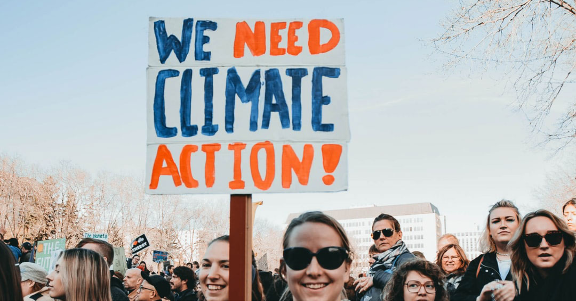 Woman holding sign that says we need climate action now