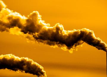 a stack pouring pollution into a yellow sky