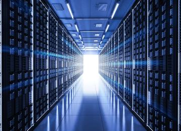 a hallway of computer servers in blue light