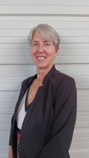 a white woman smiling in front of a white background