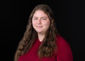 photo of evvie halpert, a white woman with long brown hair wearing a red shirt