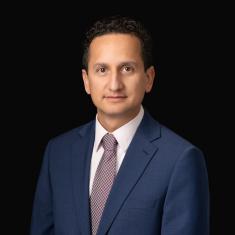 photo of Nicolas Vargas, a man with short hair, in a dark suit against a black background 