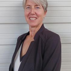 a white woman smiling in front of a white background