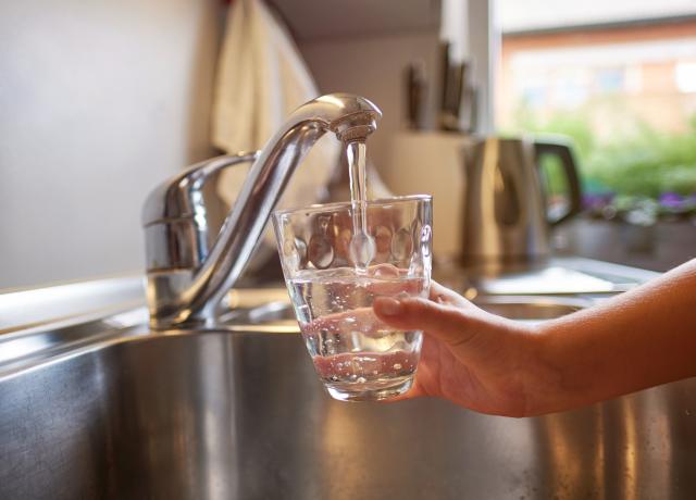 image of hand filling up glass of water at a sink