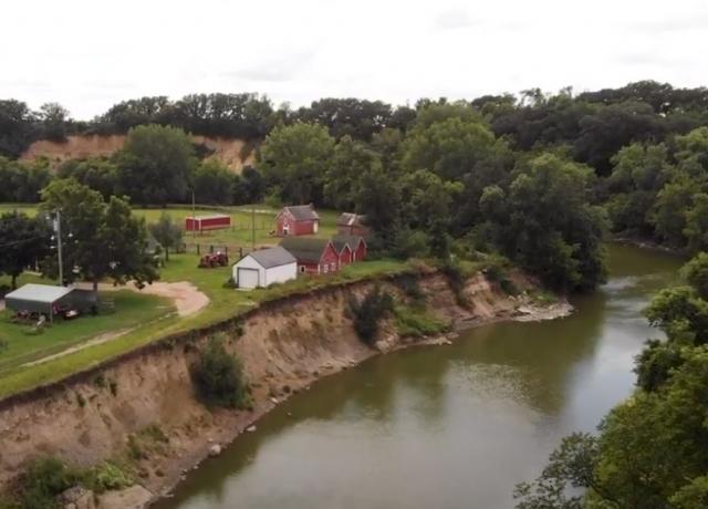 Riverbank erosion encroaching on a farm