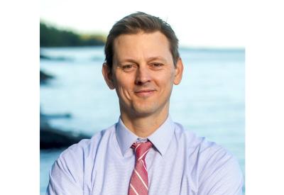 photo of j t haines a white man in red tie standing in front of lake superior