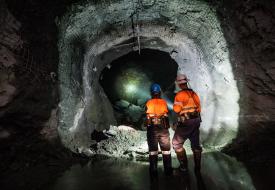 Miners looking into darkness with flashlight