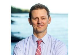 photo of j t haines a white man in red tie standing in front of lake superior