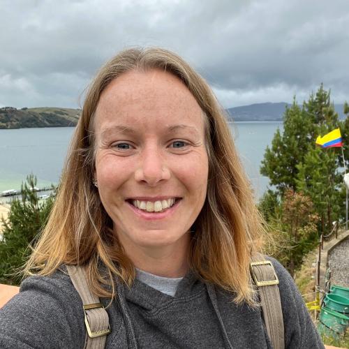 aubree, a white woman, standing in front of a lake smiling