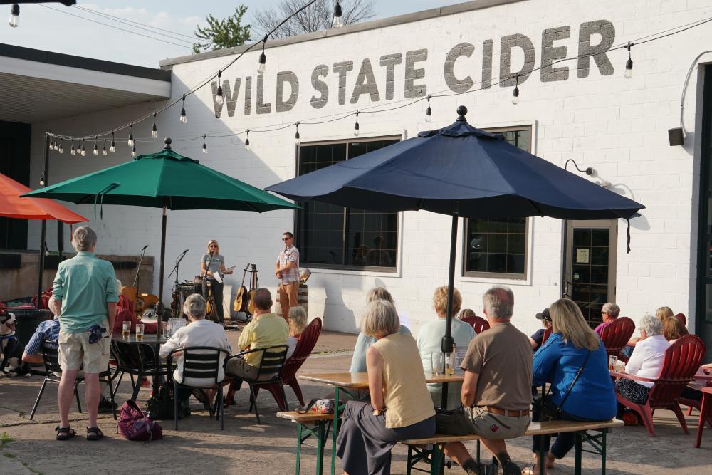 photo of supporters listening to M C E A staff giving a speech at Wild State Cider